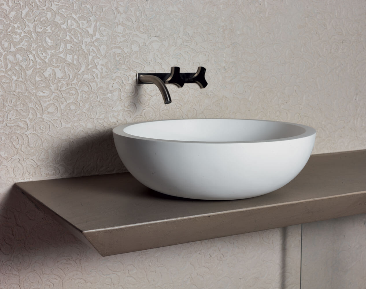Edle, fugenlose Waschschüssel auf modernem Regal mit stilvollem Wasserhahn in hellem Badezimmer.