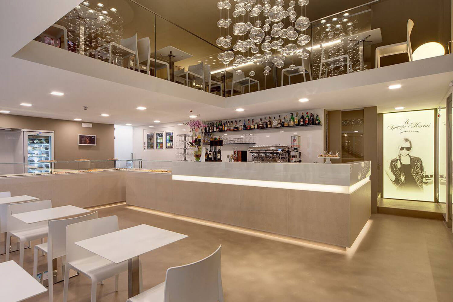 Moderne Café-Interieur mit Bar, eleganten Tischen und stilvollem Beleuchtungskonzept.