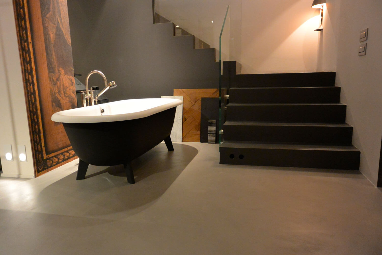 Moderne Badgestaltung mit freistehender Wanne und eleganter Treppe in fugenloser Oberfläche.