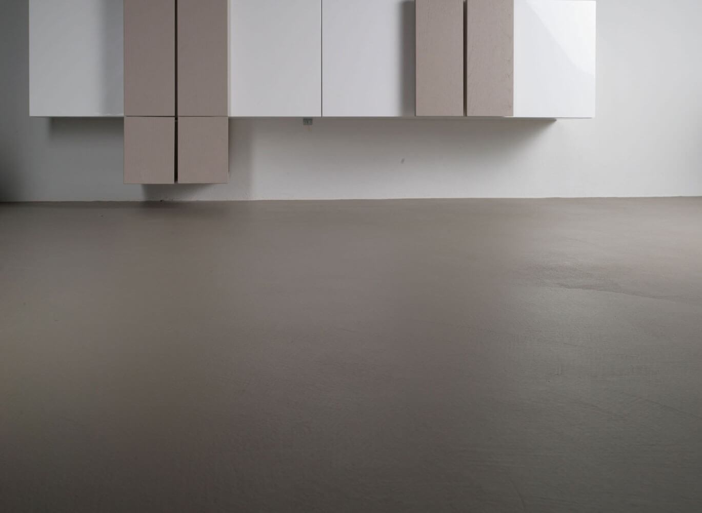 Fugenloser Boden und moderne Möbelfronten in neutralen Farbtönen. Ideal für individuelle Gestaltung.